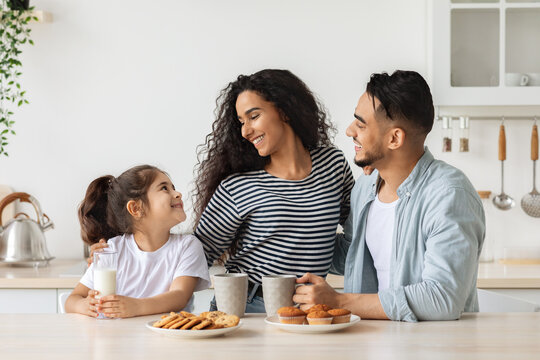 Cute happy family having breakfast while spending weekend at home