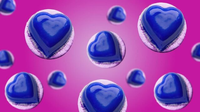 Flying and wiggle of different diameters Heart shape mousse cake decorated blue chocolate glaze on trending pink color gradient background. Romantic Love concept for mother's, St. Valentine's and wome