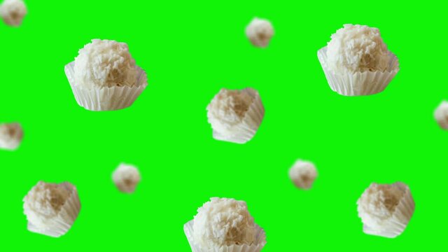 Raffaello balls with almonds and condensed milk inside and covered with coconut shavings flying and wiggle on green screen background. Love template valentine's day gift. Professional motion design 4k