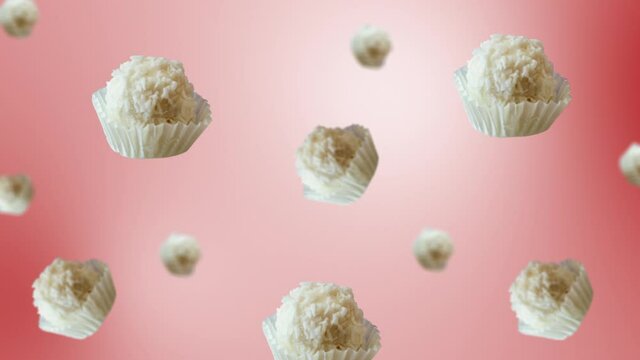 Flying and wiggle of different diameters Raffaello White Chocolate Candy With Coconut Topping on trending pink color gradient background. Romantic Love concept for mother's, St. Valentine's and women'