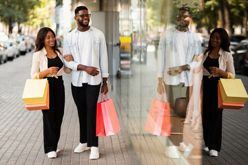 Beautiful black couple walking with shopping bags