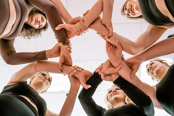 Team of people holding hands. Group of happy young women holding hands. Bottom view, low angle shot...