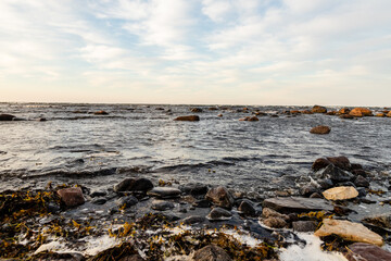 Rocky sea coast at dusk. Calm waves are reaching to coast during sunset. Coastal rocks and motion of ripples at sundown at Tahkuna, Hiiumaa, Estonia