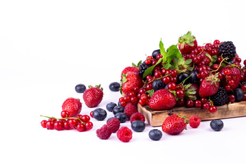 Ripe berries mixed assortment on wooden board on white background. Summer berries background. Cloce up image with copy space.