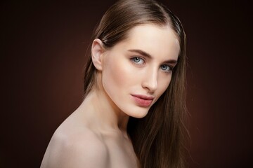Fototapeta premium Spa and beautiful concept. Standing half-turned natural beauty woman with no make up face portrait. Healthy pure skin model posing on camera isolated on black background. Natural make up concept
