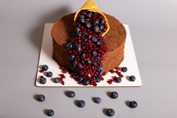 Cornucopia decoration on a cake with fresh berries. Beautiful decorat cake on grey background.