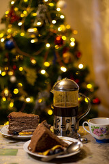 Dessert for Christmas evening. French press with coffe and piece of cake.