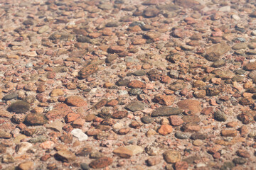 Seabed with round pebble under shallow water
