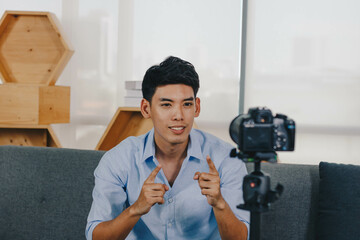 A young attractive Asian man is recoding footage for online contents.