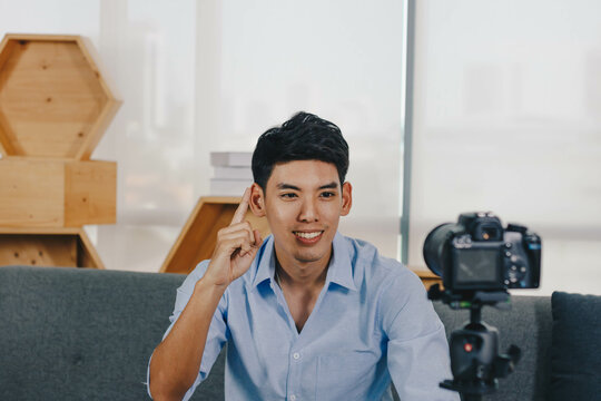 A young attractive Asian man is recoding footage for online contents.