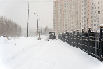 Tractor clears snow from the sidewalk
