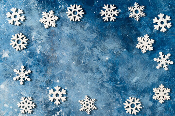 Christmas or winter composition with frame. Banner made of snowflakes on blue background. The concept of Christmas, New Year, holidays, holidays, copy space or wallpaper for your design. Flat lay.