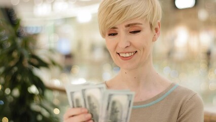 Successful caucasian middle aged woman checking amount cash money happy with financial payment. Closeup rich businesswoman holding dollars bills enjoying dollar banknotes counting win lottery income