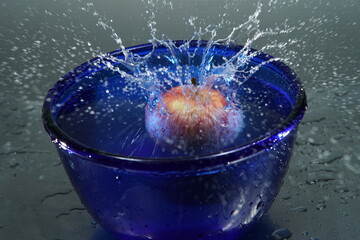 Apfel fällt in Wasserschüssel