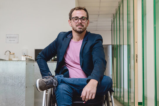 portrait of smiling businessman in a wheelchair inside an office