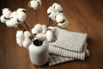 Clean folded kitchen towels and cotton flowers on the table.