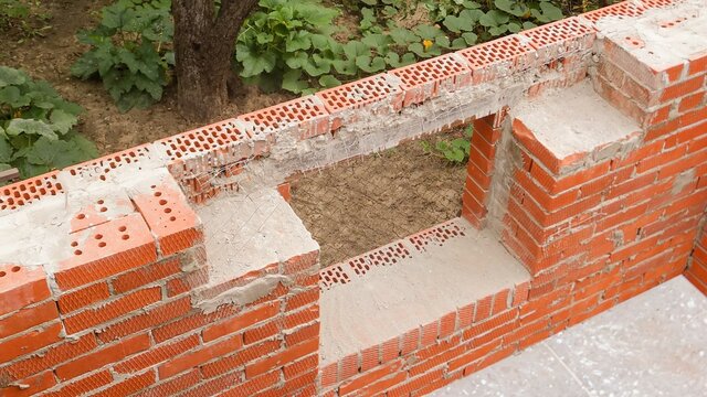Place for installing reinforced concrete window lintel in country house under construction. Close-up. External facing brickwork above window is made on reinforced metal corner.