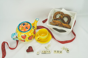 Walentynkowe śniadanie, dzbanek, filiżanka, bajgle, napis z drewnianych klocków kocham cię.
