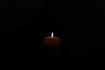 Candle surrounded by total darkness