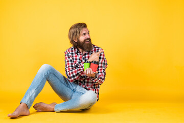 good morning. energetic warm take away beverage. pointing finger on copy space for advertisement. happy bearded man drinking morning coffee. man drink hot tea from paper cup. look here. copy space
