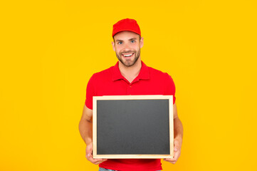 happy man in cap with blackboard. guy make announcement.