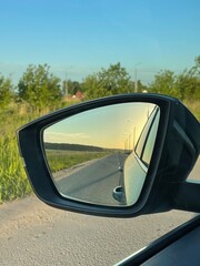 reflection of an empty rural road in a side mirror