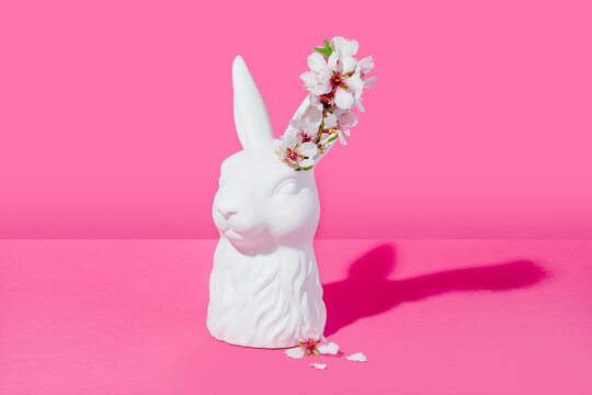 Bust of a white rabbit with almond blossoms on a pink background - Powered by Adobe