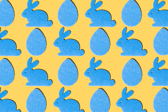 Blue rabbits and blue eggs pattern on a yellow background