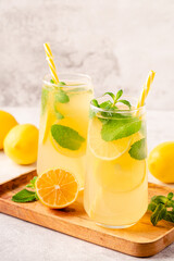 Obraz na płótnie Canvas Lemonade with lemon, mint and ice cubes in glass