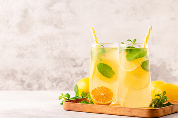 Fototapeta premium Lemonade with lemon, mint and ice cubes in glass