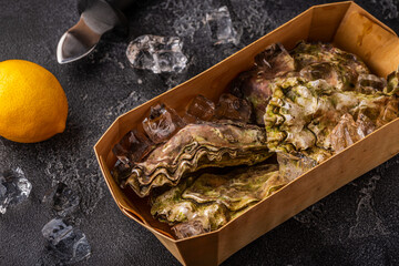 Fresh oysters close-up on ice served with lemon and wine.