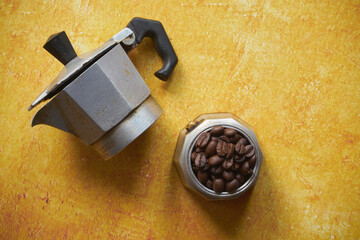 Obraz premium ziarna kawy w kawiarce na żółtym tle
