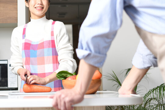キッチンで料理をする若い夫婦（カップル）のイメージ