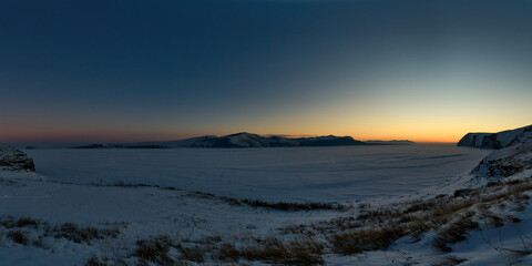 Sunset, view from the bank of the frozen river.