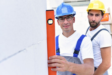teamwork on the building site - construction workers build a family home