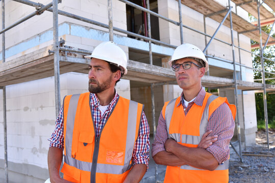 teamwork on the construction site - site manager and architect on site during the construction of a house