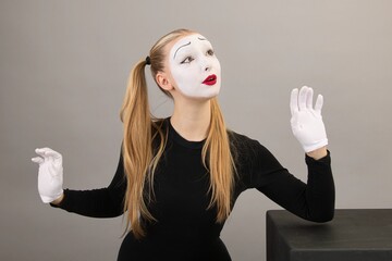 Circus girl, mime artist near the black cube.