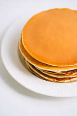 Tasty pancakes in a white plate on the table. Close-up