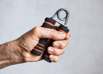 Hand of Asian, Chinese old man gripping hand exercise gripper.