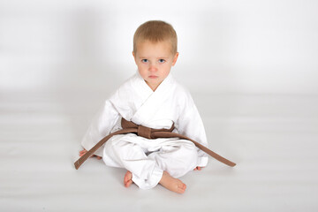 Little baby boy in karate kimono isolated on white background. The concept of martial arts, karate,...