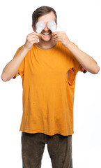 A man in a torn orange T-shirt and old corduroy brown trousers smiles broadly, covering his eyes with bulbs. blurred image. isolated, white background