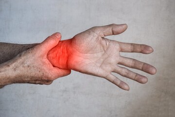 Fototapeta premium Pain in wrist joint of Asian elder man. Concept of hand pain, rheumatoid arthritis and arm problems.