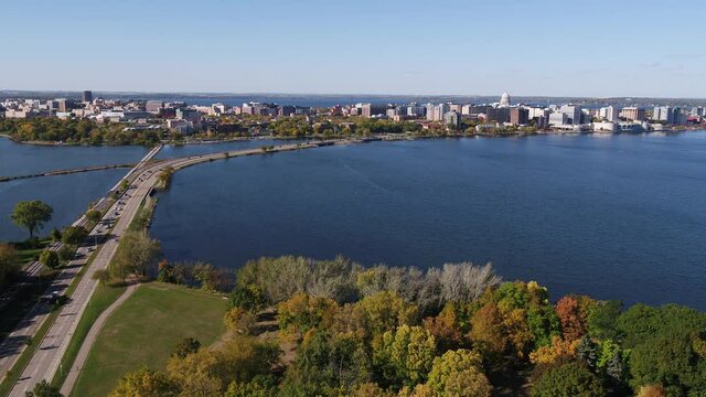 In Olin Park Flying Over John Nolen Drive towards Downtown Madison, Wisconsin Surrounded by Fall Colors (Drone - Push In)