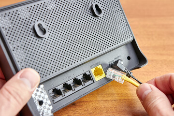 A man connects a router to the Wi-Fi Internet