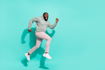 Fototapeta na wymiar Full length body size view of attractive cheerful trendy guy jumping going copy space isolated over vivid teal turquoise color background