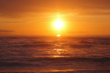 Fototapeta na wymiar puesta de sol dorado sobre las olas del mar