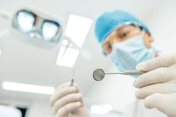 Point of view of a patient during regular dental check-ups. Caucasian male dentist using dental instruments to fix the patient’s teeth.