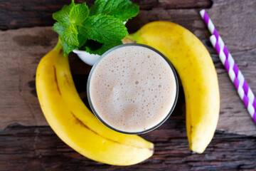 Banana fresh cocktail vanilla smoothies  fruit juice beverage healthy the taste yummy in glass drink episode good morning on wooden background from the top view.