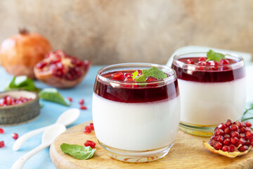 Winter panna cotta with pomegranate jelly and mint, italian dessert, homemade cuisine. Copy space. - obrazy, fototapety, plakaty