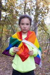 Portrait of little girl with rainbow flag. lgbtq concept.